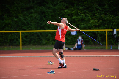 Eine Person der Seniorenklasse holt mit dem blauen Speer über der Schulter zum Wurf aus beim Walfried-Heinz-Sportfest der TG Konz im Saar-Mosel-Stadion in Konz.