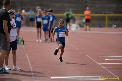 Ein Kind sprintet konzentriert über die Laufbahn beim Walfried-Heinz-Sportfest der TG Konz im Saar-Mosel-Stadion in Konz.