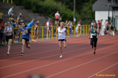 Mehrere Aktive sprinten nebeneinander über die Rundbahn beim Walfried-Heinz-Sportfest der TG Konz im Saar-Mosel-Stadion in Konz.