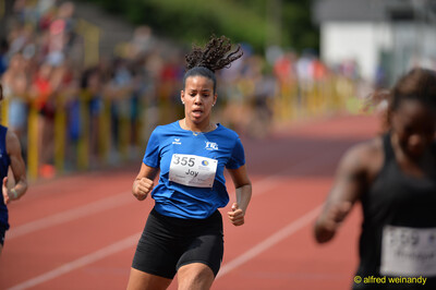 Eine Person im blauen TG-Konz-Trikot läuft auf der Rundbahn beim Walfried-Heinz-Sportfest der TG Konz im Saar-Mosel-Stadion in Konz.