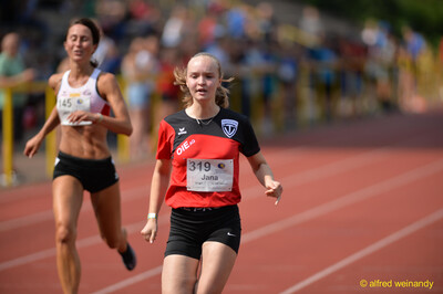 Zwei Aktive laufen im Zieleinlauf auf der Rundbahn beim Walfried-Heinz-Sportfest der TG Konz im Saar-Mosel-Stadion in Konz.