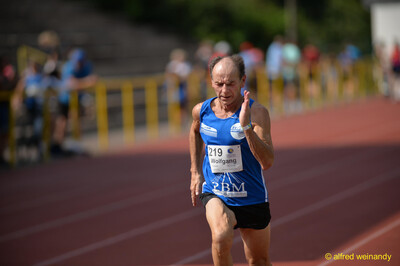 Eine Person läuft konzentriert über die rote Laufbahn beim Walfried-Heinz-Sportfest der TG Konz im Saar-Mosel-Stadion in Konz.