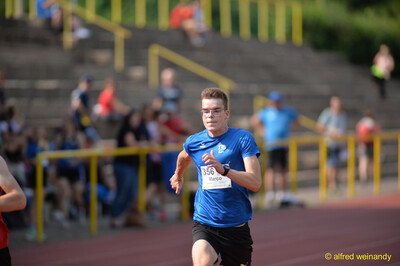 Eine jugendliche Person läuft konzentriert über die Laufbahn beim Walfried-Heinz-Sportfest der TG Konz im Saar-Mosel-Stadion in Konz.