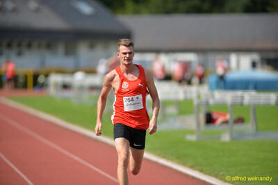Eine Person sprintet konzentriert über die Rundbahn beim Walfried-Heinz-Sportfest der TG Konz im Saar-Mosel-Stadion in Konz.