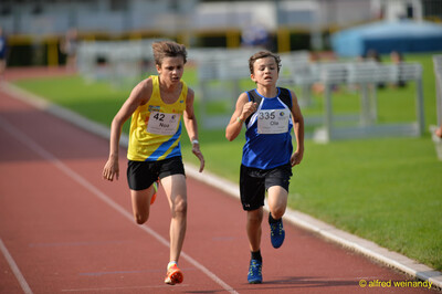 Zwei Kinder sprinten dicht nebeneinander über die Laufbahn beim Walfried-Heinz-Sportfest der TG Konz im Saar-Mosel-Stadion in Konz.