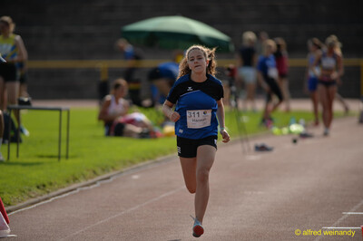 Eine Person im blauen Trikot sprintet allein über die Laufbahn beim Walfried-Heinz-Sportfest der TG Konz im Saar-Mosel-Stadion in Konz.