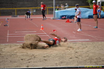 Eine Person landet beim Weitsprung mit aufstäubendem Sand in der Sandgrube beim Walfried-Heinz-Sportfest der TG Konz im Saar-Mosel-Stadion in Konz.