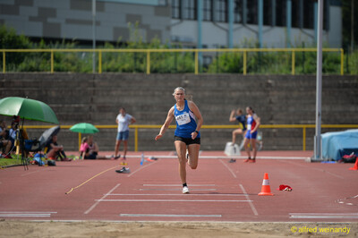 Eine Person sprintet über die Weitsprung-Anlaufbahn und nimmt Anlauf zum Absprung, beim Walfried-Heinz-Sportfest der TG Konz im Saar-Mosel-Stadion in Konz.
