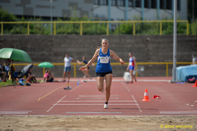 Eine Person befindet sich in der Flugphase eines Weitsprungs über der Sandgrube beim Walfried-Heinz-Sportfest der TG Konz im Saar-Mosel-Stadion in Konz.