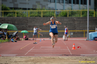 Eine Person fliegt hoch durch die Luft über der Weitsprunggrube beim Walfried-Heinz-Sportfest der TG Konz im Saar-Mosel-Stadion in Konz.