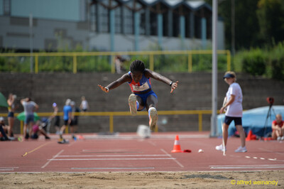 Eine Person streckt in der Flugphase des Weitsprungs die Arme aus und schwebt über der Sandgrube beim Walfried-Heinz-Sportfest der TG Konz im Saar-Mosel-Stadion in Konz.