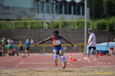 Eine Person streckt vor der Landung des Weitsprungs die Beine zur Sandgrube aus beim Walfried-Heinz-Sportfest der TG Konz im Saar-Mosel-Stadion in Konz.