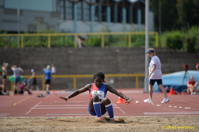 Eine Person landet mit aufstäubendem Sand in der Weitsprunggrube beim Walfried-Heinz-Sportfest der TG Konz im Saar-Mosel-Stadion in Konz.
