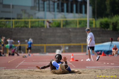 Eine Person sitzt nach der Weitsprung-Landung im aufgewühlten Sand der Sandgrube beim Walfried-Heinz-Sportfest der TG Konz im Saar-Mosel-Stadion in Konz.