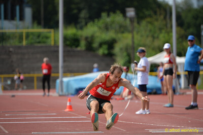 Eine Person streckt beim Weitsprung vor der Landung die Beine nach vorn beim Walfried-Heinz-Sportfest der TG Konz im Saar-Mosel-Stadion in Konz.
