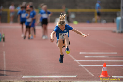 Ein Kind springt in der Flugphase eines Weitsprungs über die Sandgrube beim Walfried-Heinz-Sportfest der TG Konz im Saar-Mosel-Stadion in Konz.