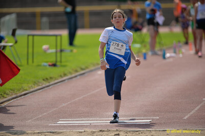 Ein Kind läuft auf den Absprungbalken und die Sandgrube zum Weitsprung zu beim Walfried-Heinz-Sportfest der TG Konz im Saar-Mosel-Stadion in Konz.
