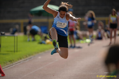 Eine Person schwebt in der Flugphase eines Sprungs über der Anlage beim Walfried-Heinz-Sportfest der TG Konz im Saar-Mosel-Stadion in Konz.