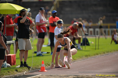 Eine Person landet beim Weitsprung mit vorgestreckten Beinen in der Sandgrube beim Walfried-Heinz-Sportfest der TG Konz im Saar-Mosel-Stadion in Konz.