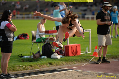 Eine Person im Flug über der Sprunggrube im Weitsprung beim Walfried-Heinz-Sportfest der TG Konz im Saar-Mosel-Stadion in Konz.