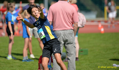 Ein Kind holt mit dem kleinen Schlagball zum Wurf aus beim Ballwurf bei der Rheinland-Meisterschaft im Mehrkampf der TG Konz in Konz.