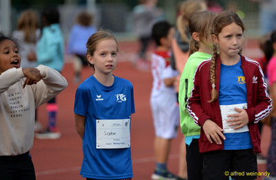 Mehrere Kinder mit Startnummern stehen wartend an der Laufbahn beim Jugendsportfest der TG Konz in Konz