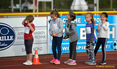 Fünf Kinder stehen in einer Reihe an einem Markierungskegel entlang der Bahn beim Jugendsportfest der TG Konz in Konz
