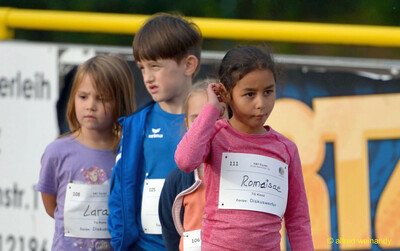 Nahaufnahme von drei Kindern mit Startnummern, die wartend auf der Anlage stehen, beim Jugendsportfest der TG Konz in Konz