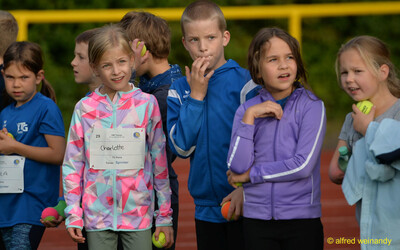 Mehrere Kinder stehen mit kleinen Bällen in den Händen auf der Laufbahn und warten auf ihren Einsatz beim Jugendsportfest der TG Konz in Konz.