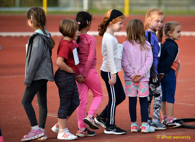 Mehrere Kinder stehen in einer Reihe auf der Laufbahn und warten auf ihren Einsatz beim Jugendsportfest der TG Konz in Konz.