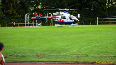 Ein rot-weißer Rettungshubschrauber steht auf dem Rasenplatz des Stadions beim Jugendsportfest der TG Konz in Konz