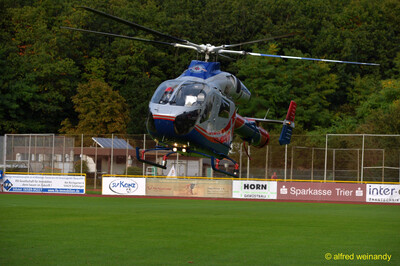 Ein Rettungshubschrauber schwebt dicht über dem Spielfeld des Stadions beim Jugendsportfest der TG Konz in Konz.
