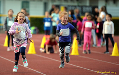 Zwei laufende Kinder sprinten auf der Laufbahn beim Jugendsportfest der TG Konz in Konz.