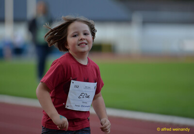 Ein laufendes Kind in rotem Shirt am Rand der Laufbahn beim Jugendsportfest der TG Konz in Konz.