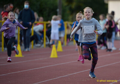 Ein Kind sprintet auf der Tartanbahn zwischen Markierungskegeln beim Jugendsportfest der TG Konz in Konz.