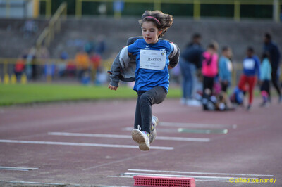 Ein Kind in der Flugphase eines Weitsprungs über dem Absprungblock beim Jugendsportfest der TG Konz in Konz.