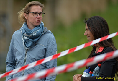 Zwei Personen unterhalten sich hinter einer Absperrung bei der Rheinland-Pfalz-Meisterschaft in Konz.