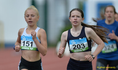 Zwei junge Laufende kämpfen auf der Bahn dicht nebeneinander um die Position bei der Rheinland-Pfalz-Meisterschaft in Konz.