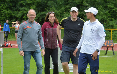Betreuung und Kampfgericht gehen über den Innenraum des Stadions bei der Rheinland-Pfalz-Meisterschaft in Konz.