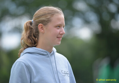 Seitliches Porträt einer jugendlichen Person mit Zopf und hellblauem Hoodie auf der Sportanlage bei der Rheinland-Pfalz-Meisterschaft in Konz.