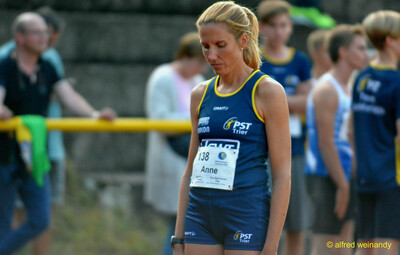 Eine Person im PST-Trier-Trikot steht konzentriert mit Startnummer vor ihrem Wettkampf beim Walfried-Heinz-Sportfest der TG Konz im Saar-Mosel-Stadion in Konz.