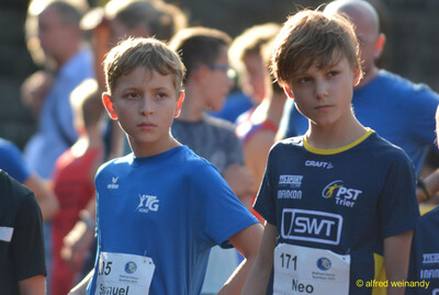 Zwei Kinder mit Startnummern warten nebeneinander vor dem Start beim Walfried-Heinz-Sportfest der TG Konz im Saar-Mosel-Stadion in Konz.