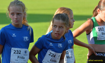 Mehrere Kinder im TG-Konz-Trikot stehen mit Startnummern auf dem Innenraum beim Walfried-Heinz-Sportfest der TG Konz im Saar-Mosel-Stadion in Konz.