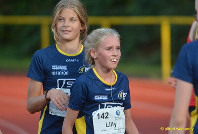 Zwei Kinder stehen lächelnd nebeneinander auf der Bahn beim Walfried-Heinz-Sportfest der TG Konz im Saar-Mosel-Stadion in Konz.