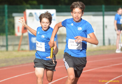 Zwei Kinder übergeben den Staffelstab in der Wechselzone beim Walfried-Heinz-Sportfest der TG Konz im Saar-Mosel-Stadion in Konz.