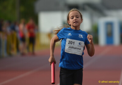 Ein Kind läuft mit dem roten Staffelstab im Staffellauf beim Walfried-Heinz-Sportfest der TG Konz im Saar-Mosel-Stadion in Konz.
