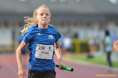 Ein Kind sprintet mit dem grünen Staffelstab im Staffellauf beim Walfried-Heinz-Sportfest der TG Konz im Saar-Mosel-Stadion in Konz.