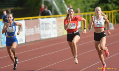 Drei Kinder sprinten nebeneinander auf der Rundbahn beim Walfried-Heinz-Sportfest der TG Konz im Saar-Mosel-Stadion in Konz.