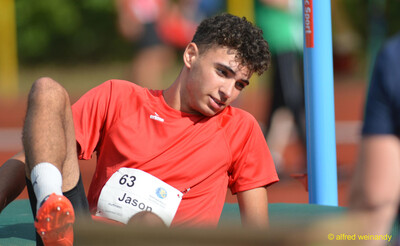 Eine jugendliche Person sitzt nach dem Sprung auf der Hochsprungmatte beim Walfried-Heinz-Sportfest der TG Konz im Saar-Mosel-Stadion in Konz.