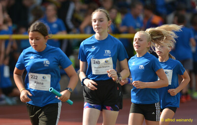 Vier Kinder laufen mit Staffelstab im Staffellauf beim Walfried-Heinz-Sportfest der TG Konz im Saar-Mosel-Stadion in Konz.